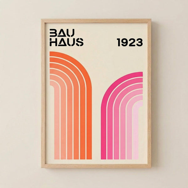 May include: Framed print displayed on beige wall featuring geometric design with two curved rainbow shapes - one in orange gradient tones on left, one in pink gradient tones on right, both made of concentric curved lines. Black text reads "BAUHAUS" and "1923" at top. Light wood frame against neutral background.