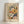May include: Framed art print featuring abstract floral painting in soft watercolor style with yellow, coral, white and blue blooms against cream background. Text reads "Henri Matisse" at top and "creativity takes courage" at bottom. Light wood frame displayed on white surface against white wall with natural lighting creating gentle shadows.