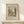 May include: Framed art print featuring a vintage landscape drawing with trees, water, and parkland in muted green and beige tones. The print shows "River and Park Landscape" text at top and "Henri Rousseau" at bottom. Displayed in a thin wooden frame on a white floating shelf against a cream wall with soft natural lighting creating gentle shadows.