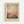 May include: Framed art print hanging on white wall showing abstract landscape with soft pink, peach, and brown tones blending into atmospheric sky above darker terrain below. Light wood frame with cream matting. Halftone dot texture visible throughout the image. Artist name displayed in serif text at bottom of print.