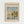 May include: Framed Claude Monet exhibition poster hanging on white wall, featuring sailboats on water with reflections in impressionist style. Light wood frame contains cream-colored poster with "CLAUDE MONET EXHIBITION GALLERY" text above painting of white-sailed boats near green shoreline under cloudy sky. Water shows blue and yellow reflections beneath vessels. Small text reads "Regattas at Argenteuil 1872" below artwork.