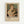 A framed exhibition poster featuring Renoir's 1875 painting "Woman with a Cat" showing a young woman in a white dress holding a tabby cat. The artwork displays soft, impressionistic brushstrokes in warm tones of peach, cream, and muted greens. Below the painting reproduction is black text reading "PIERRE AUGUSTE exhibition" with "1875" and "Woman with a Cat" in smaller text. The poster has a cream-colored matted border within a light wooden frame, mounted on a whi