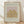 May include: Framed art print featuring Matisse exhibition poster with golden botanical cutout design on pink and cream background, displayed against white textured wall on light wood floor with natural lighting creating soft shadows