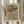 May include: Framed art print featuring flowing wave-like patterns in earth tones of brown, cream, orange and muted colors against a beige background, displayed on a light wooden surface beside dried pampas grass stems, with soft natural lighting and neutral fabric in a minimalist home setting.