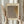 May include: Person in cream sweater holding framed art print with light wood frame, featuring abstract dotted pattern in brown and tan tones with Japanese text. Dried pampas grass visible to left, soft natural lighting against neutral curtained background.