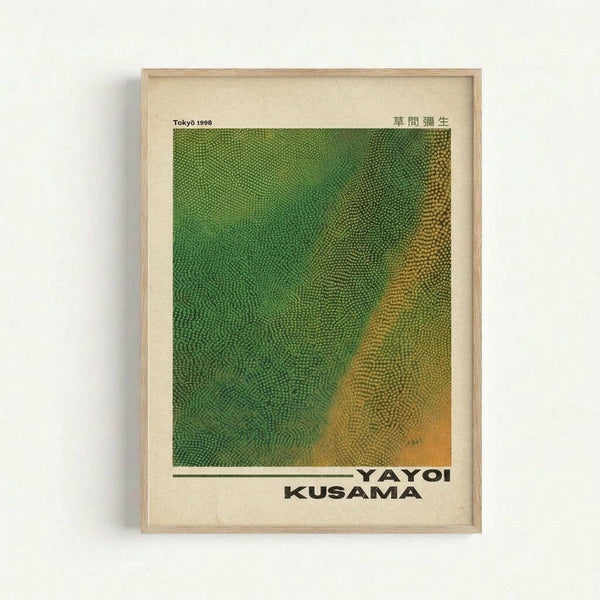 Framed art print featuring a textured green and golden yellow gradient pattern with small dotted details. The poster displays "Tokyo 1998" and Japanese characters at the top, with "YAYOI KUSAMA" printed at the bottom in bold black letters. The artwork is mounted in a light wooden frame against a white wall, showing organic flowing textures that transition from vibrant green on the left to warm golden tones on the right.
