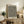 May include: Framed art print with black wavy lines and yellow dots in organic flowing pattern, displayed on rustic wooden sideboard next to fern plant, books, and ceramic vases in warm neutral living room setting with beige armchair visible