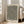 May include: Large framed poster with black and white organic flowing lines and small yellow dots, leaning against white wall beside beige sofa in bright living room with tall windows and natural light casting shadows on wooden floor.