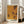 May include: Large framed poster with abstract orange and black dotted pattern reminiscent of Yayoi Kusama's signature polka dot style, displayed in bright modern living room with white walls, large windows, and beige sectional sofa on light wooden floors