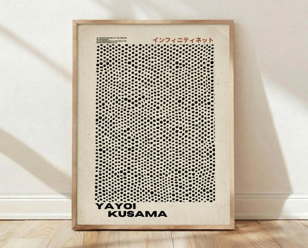 May include: Framed art print with cream background featuring dense pattern of black polka dots that fade from large to small, creating optical illusion effect. Japanese text appears at top, bold black text at bottom. Natural wood frame sits against white textured wall on light wooden floor with soft natural lighting casting gentle shadows.