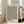 May include: Framed art print with black polka dot pattern on cream background, featuring Japanese text and "YAYOI KUSAMA" at bottom, displayed in light wood frame leaning against white wall next to beige upholstered chair in bright living room with large windows