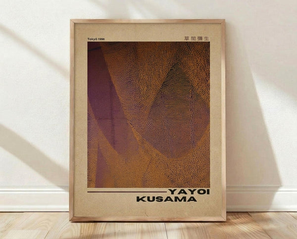 May include: Framed art poster with abstract orange and burgundy textured pattern resembling organic cellular forms or dotted waves. Light wood frame with cream matting, leaning against white wall on light wooden floor with natural window shadows cast across the scene.