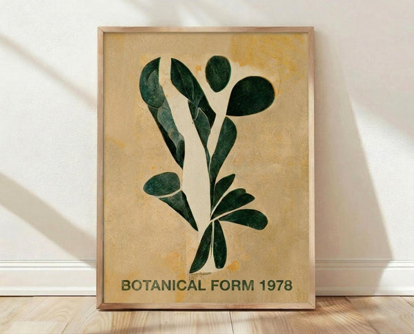 May include: Framed botanical poster with dark green leaves arranged in an artistic spray pattern on aged beige background with yellow-orange staining effects. Text reads "BOTANICAL FORM 1978" at bottom. Natural wood frame sits on light wooden floor against white wall with soft shadows from window light.