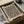 May include: Framed art print with abstract black curved lines and small red dots on cream background, displayed in black frame inside open cardboard shipping box with protective tissue paper and wooden dowels for packaging
