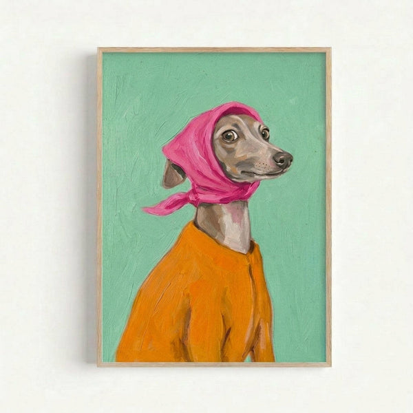 A framed painting of an Italian Greyhound wearing a bright pink headscarf and orange sweater against a mint green background. The dog has large expressive eyes and tan and brown coloring. The artwork is displayed in a simple wooden frame against a white wall, showing visible paint texture and brushstrokes in a portrait style.