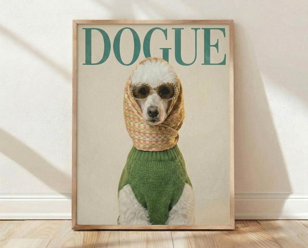 May include: Framed poster featuring a white poodle wearing round sunglasses, colorful striped headscarf, and green knit sweater against cream background. Green "DOGUE" text at top parodies fashion magazine cover. Light wood frame sits on wooden floor against white wall with soft natural lighting and fabric shadows.