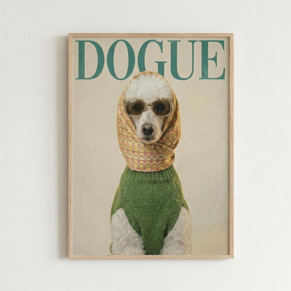 May include: Framed poster print hanging on white wall showing a white poodle wearing dark sunglasses, green knit sweater, and colorful striped scarf wrapped around its head. The word "DOGUE" appears in large green letters at the top against a cream background, styled like a fashion magazine cover. Natural wood frame.