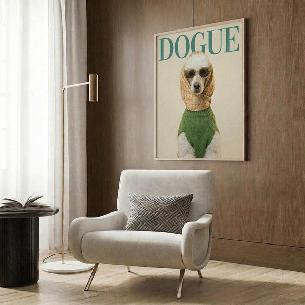 May include: Framed poster featuring a white poodle wearing green sweater, wicker hood and sunglasses on cream background with "DOGUE" text in teal letters, displayed above beige upholstered chair with geometric pillow in modern room with wood paneling, brass floor lamp, and dark round side table with open book
