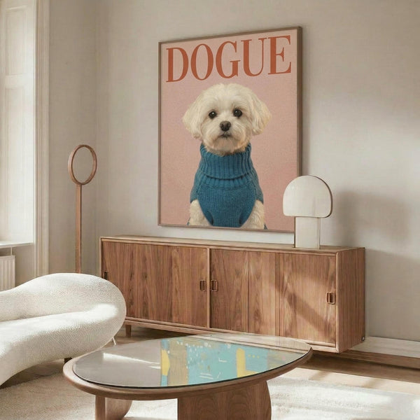 May include: Framed poster featuring a small white Maltese dog wearing a blue turtleneck sweater against a pink background with "DOGUE" text at top, displayed on a wooden sideboard in a modern living room with cream chair, oval glass coffee table, and neutral decor