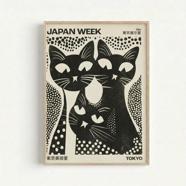 Black and white vintage-style poster featuring three stylized cats with large eyes and whiskers, surrounded by dotted patterns. The cats are rendered in a bold graphic style with white negative space details. Text reads "JAPAN WEEK" at top and "TOKYO" at bottom, with Japanese characters and "1984" visible. The poster is displayed in a light wood frame against a white wall, showing cream-colored paper with high contrast black ink design elements throughout.