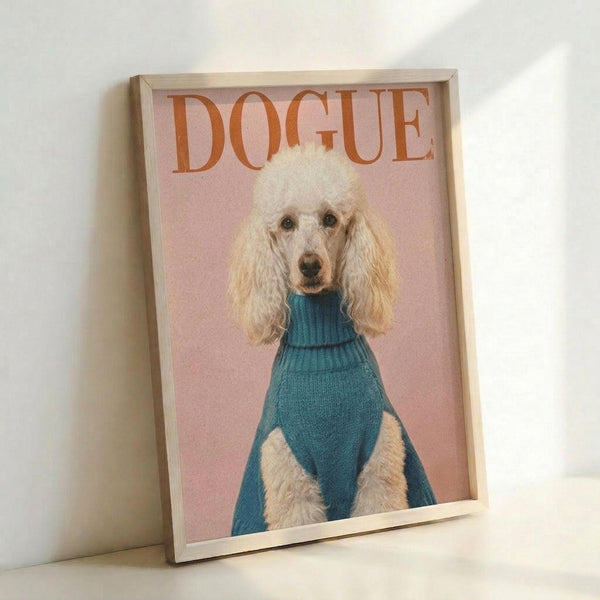 May include: Framed poster print leaning against white wall corner showing poodle with fluffy cream-colored coat wearing teal turtleneck sweater on soft pink background with "DOGUE" text in orange serif letters at top, displayed in light wood frame