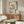 May include: Japanese-inspired artwork featuring three red fish with spotted patterns swimming among green seaweed and coral-colored flowers on a cream background, displayed above a mid-century modern walnut credenza in a minimalist living room with white curved chair and oval glass coffee table