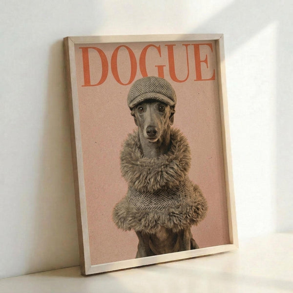 May include: Framed poster print leaning against white wall showing a whippet or greyhound wearing a herringbone flat cap and furry brown coat against a pink background, with "DOGUE" text in orange letters at top, displayed in light wooden frame on white surface