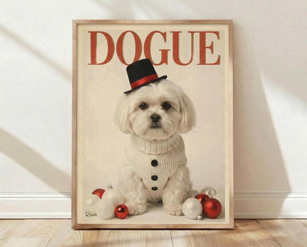 May include: Framed poster print featuring a white Maltese dog wearing a black top hat with red band and cream knit sweater, sitting among red and white Christmas ornaments. The word "DOGUE" appears in large red letters at the top. Light wood frame against white textured wall on wooden floor.