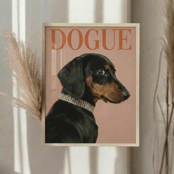 May include: Framed poster with coral pink background featuring a black and tan dachshund in profile wearing a sparkly rhinestone collar, with "DOGUE" text in orange letters at top, displayed on white wall next to dried pampas grass in neutral home setting