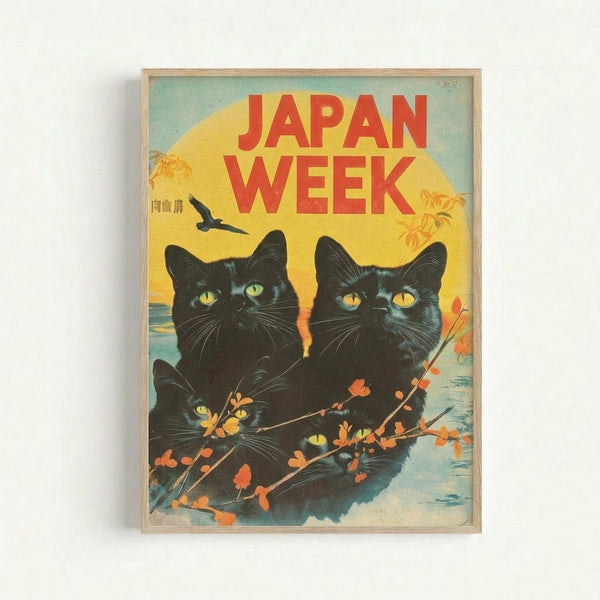 Framed vintage-style poster featuring two black cats with bright yellow-green eyes sitting together against a sunset backdrop. The cats are surrounded by delicate flowering branches with orange and pink blossoms. Bold red text reads "JAPAN WEEK" at the top, with a flying bird silhouette and Japanese characters visible. The artwork has a warm yellow sun, blue water, and retro color palette, displayed in a light wood frame against a white wall.