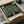 May include: Vintage-style botanical poster featuring an ornate fruit tree with golden apples and green foliage against a dark blue background, displayed in a black frame inside an open cardboard shipping box with protective packaging materials on a white surface.