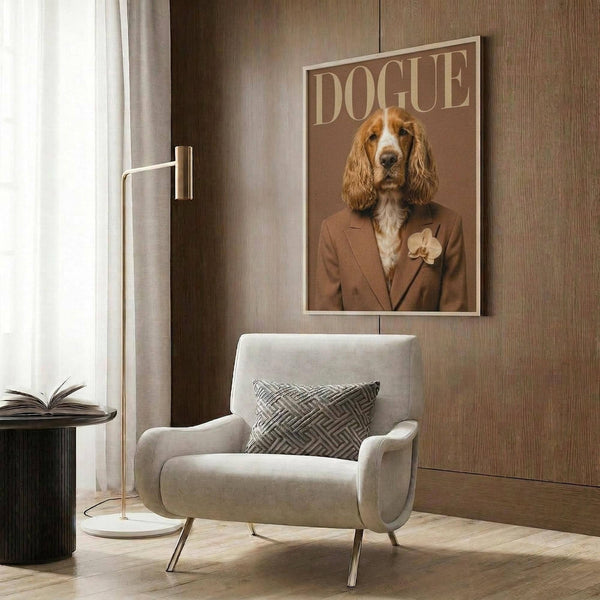 May include: Framed poster on wood-paneled wall featuring a golden cocker spaniel wearing a tan suit jacket with flower boutonniere on magazine-style cover reading "DOGUE." Modern living room setting with cream armchair, geometric throw pillow, gold floor lamp, and dark side table with open book.
