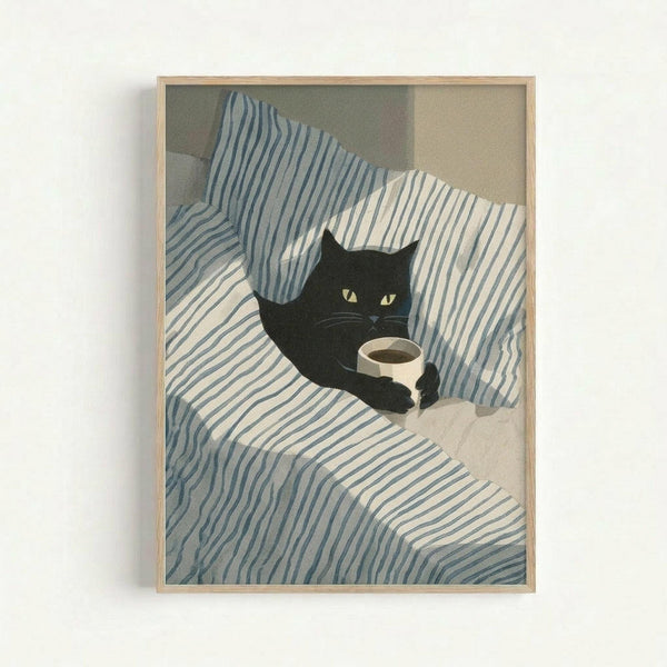 May include: Framed poster print hanging on white wall showing black cat with yellow eyes sitting on blue and white striped bedding next to coffee cup. Artwork has soft, illustrated style with muted colors. Light wood frame surrounds the print.
