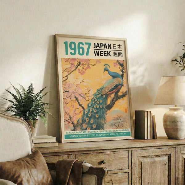 May include: Framed vintage-style poster featuring a blue and teal peacock perched on cherry blossom branches against a golden sunset sky, displayed on a rustic wooden sideboard next to potted plants, ceramic vases, and books in a cozy living room with neutral tones and natural lighting.