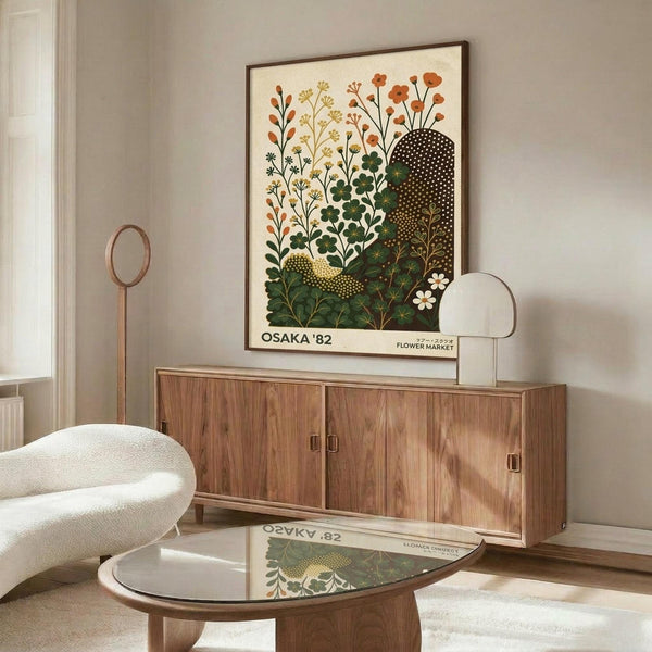 May include: Framed botanical poster featuring stylized plants and flowers in warm oranges, greens, and yellows on cream background, displayed above mid-century walnut credenza in modern living room with white sculptural chair, glass coffee table, and minimalist decor