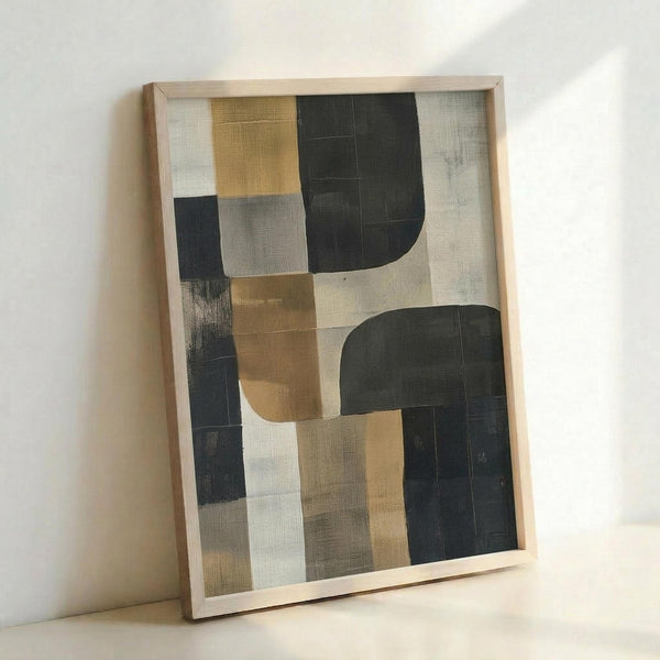 May include: Abstract geometric artwork in light wooden frame leaning against white wall. Features overlapping rectangular and curved shapes in muted palette of charcoal black, warm ochre yellow, soft grays, and cream. Painted with visible brushstrokes and textural elements creating layered, modern composition with organic flowing forms intersecting angular blocks.