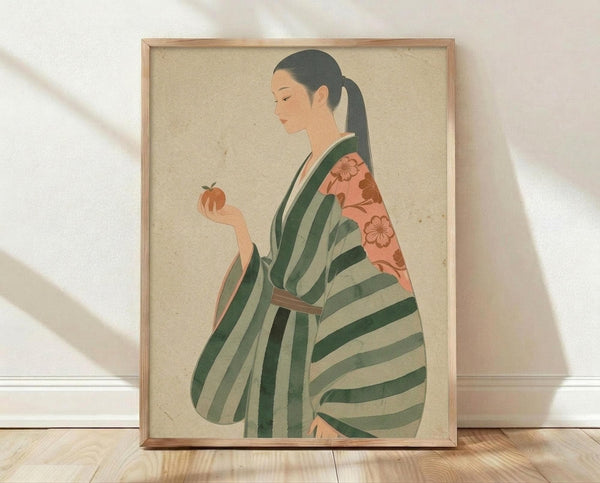 May include: Framed vintage-style illustration of Japanese woman in profile wearing green and cream striped kimono with coral floral obi, holding small orange persimmon fruit. Art has warm beige textured background, displayed in light wood frame leaning against white wall on wooden floor with soft natural lighting casting shadows.