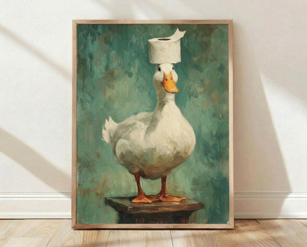 May include: Framed art print leaning against white wall on light wooden floor. The artwork shows a white duck or goose with orange beak and feet, standing on a wooden surface with a toilet paper roll balanced on its head. Painted in realistic style with muted green-blue textured background. Natural wood frame visible around the print.