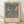 May include: Framed vintage exhibition poster featuring two colorful birds perched among strawberry plants with red berries and flowing vines on deep blue background. Light wood frame sits on wooden floor against white wall with natural lighting casting soft shadows.