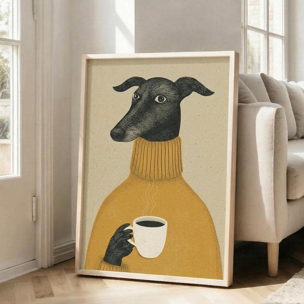 May include: Framed artwork showing a black greyhound wearing a mustard yellow turtleneck sweater, holding a white coffee cup with steam rising from it. The illustration has a vintage engraved style against a cream background. The wooden frame leans against a white wall next to a beige upholstered chair in a bright room with large windows.