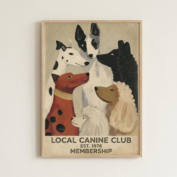 May include: Framed vintage-style poster showing six painted dogs of different breeds and colors including a spotted dalmatian, reddish-brown dog, black dog, white fluffy dog, and others arranged in a group portrait style. Text reads "LOCAL CANINE CLUB EST. 1976 MEMBERSHIP" at bottom. Light wood frame mounted on white textured wall, beige canvas background with painterly brushstroke texture.
