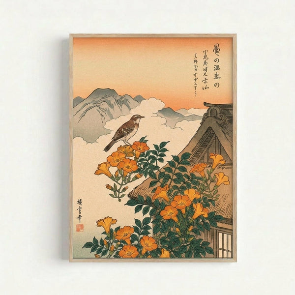 Japanese woodblock print featuring a brown bird perched on orange trumpet vine flowers with green leaves. A traditional thatched-roof house sits in the lower right corner against misty mountains and an orange sunset sky. Black Japanese calligraphy appears in the upper right. The artwork has muted earth tones and is displayed in a thin wooden frame against a white wall.