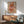 May include: Framed retro poster with colorful pasta noodles swirling around a fork on beige background, displaying "PASTA LA VISTA" text. Shown in modern living room with mid-century wooden sideboard, sage green armchair, white ceramic lamp, and natural sunlight casting shadows on white walls.