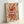 May include: Framed poster with cream background featuring colorful swirled pasta noodles in red, orange, yellow and green ribbons around a black fork. Bold white text reads "PASTA LA VISTA" with smaller text below. Displayed in light wood frame leaning against white wall.