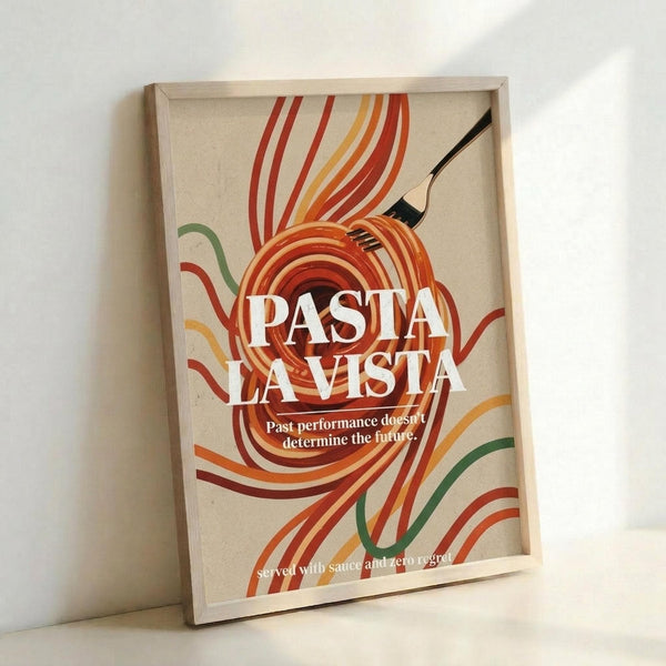 May include: Framed poster with cream background featuring colorful swirled pasta noodles in red, orange, yellow and green ribbons around a black fork. Bold white text reads "PASTA LA VISTA" with smaller text below. Displayed in light wood frame leaning against white wall.