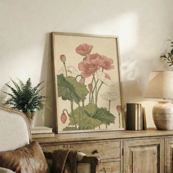 May include: Vintage botanical illustration of pink poppies with green stems and leaves in light wood frame, displayed on rustic wooden console table alongside fern plant, stacked books, and ceramic vase in neutral-toned living room setting
