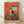 May include: Framed art print leaning against white wall on light wood floor. The artwork shows a black and white tuxedo cat sitting on a turquoise wooden chair against a textured orange-red wall. Three small dark birds perch on top of the chair back, with two more birds on the ground below. The vintage-style illustration has a weathered, painterly texture. Natural wood frame surrounds the print.