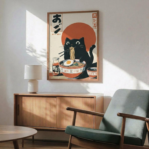 May include: Japanese-style poster print featuring a black cat eating ramen noodles from a decorative bowl, set against a large orange sun with Japanese text characters. The artwork shows vintage ukiyo-e styling in cream, orange, and black colors, displayed in a wooden frame above a mid-century modern walnut credenza. Scene includes a teal upholstered armchair, white ceramic lamp, and warm natural lighting on white walls.