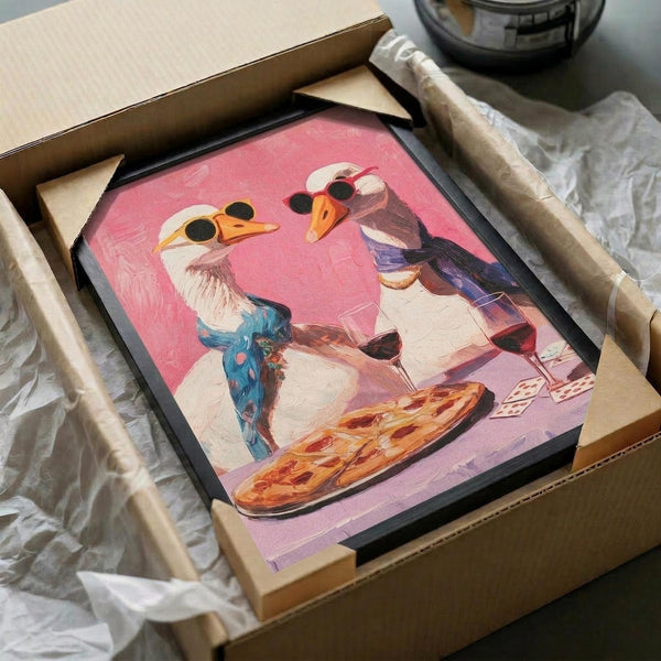 May include: Whimsical artwork showing two geese wearing sunglasses sharing pizza and wine on a pink background, displayed in a black frame nestled in brown cardboard packaging with white tissue paper protection.