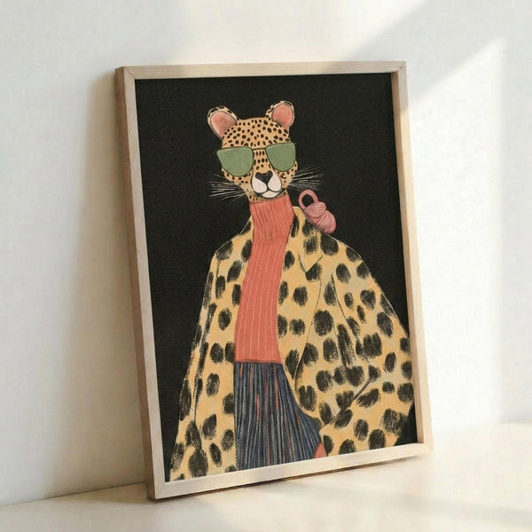 May include: Framed art print featuring a stylized leopard wearing green sunglasses, coral ribbed turtleneck, leopard print coat, and blue striped pants while holding a pink purse, set against a black background in a light wood frame, leaning against a white wall